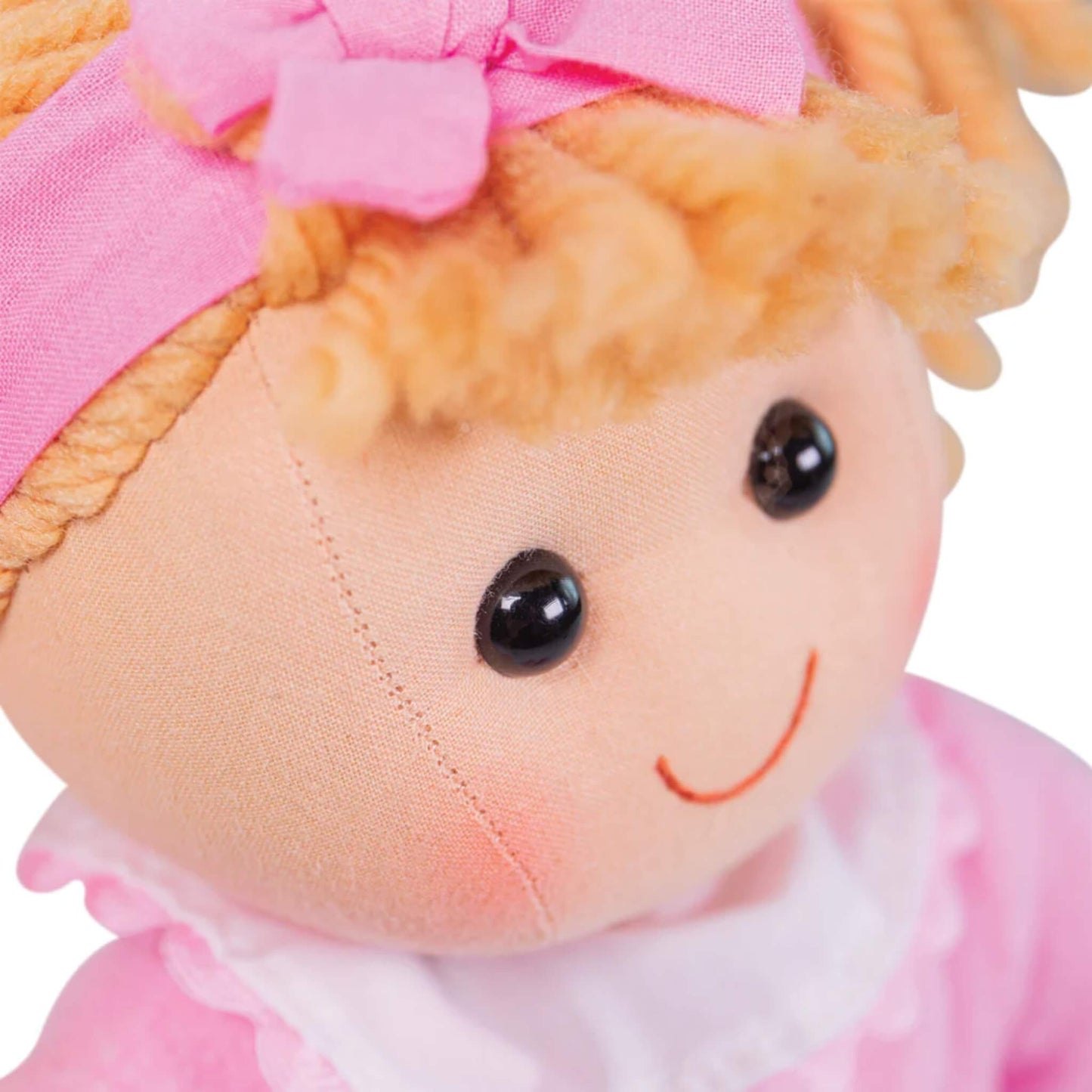 Detailed close-up of Kelly’s face showing her black stitched eyes, embroidered smile and plush fabric texture.