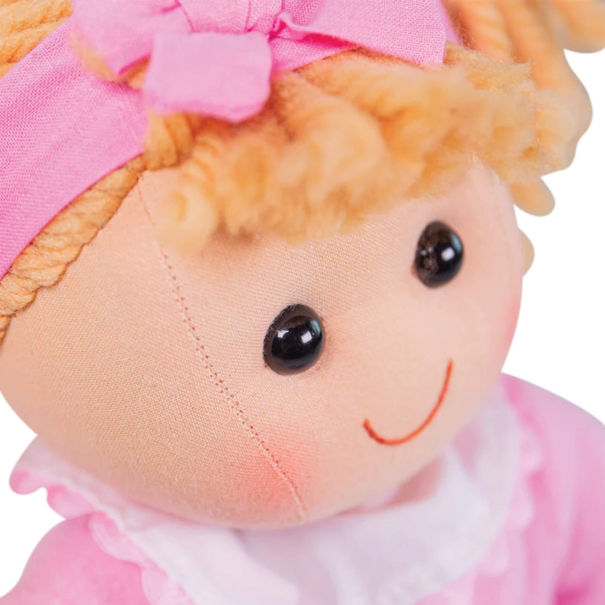 Detailed close-up of Kelly’s face showing her black stitched eyes, embroidered smile and plush fabric texture.