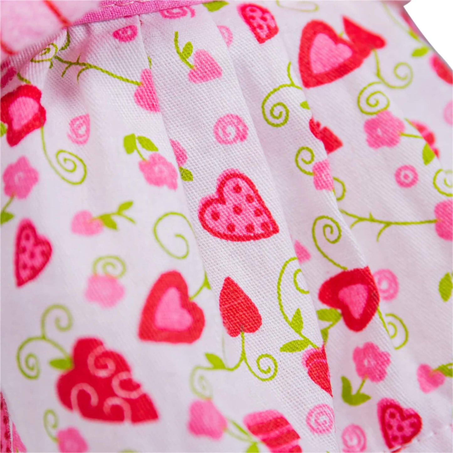 Close-up of Kelly’s dress fabric showing scattered hearts, strawberries, and flowers in pink and red.