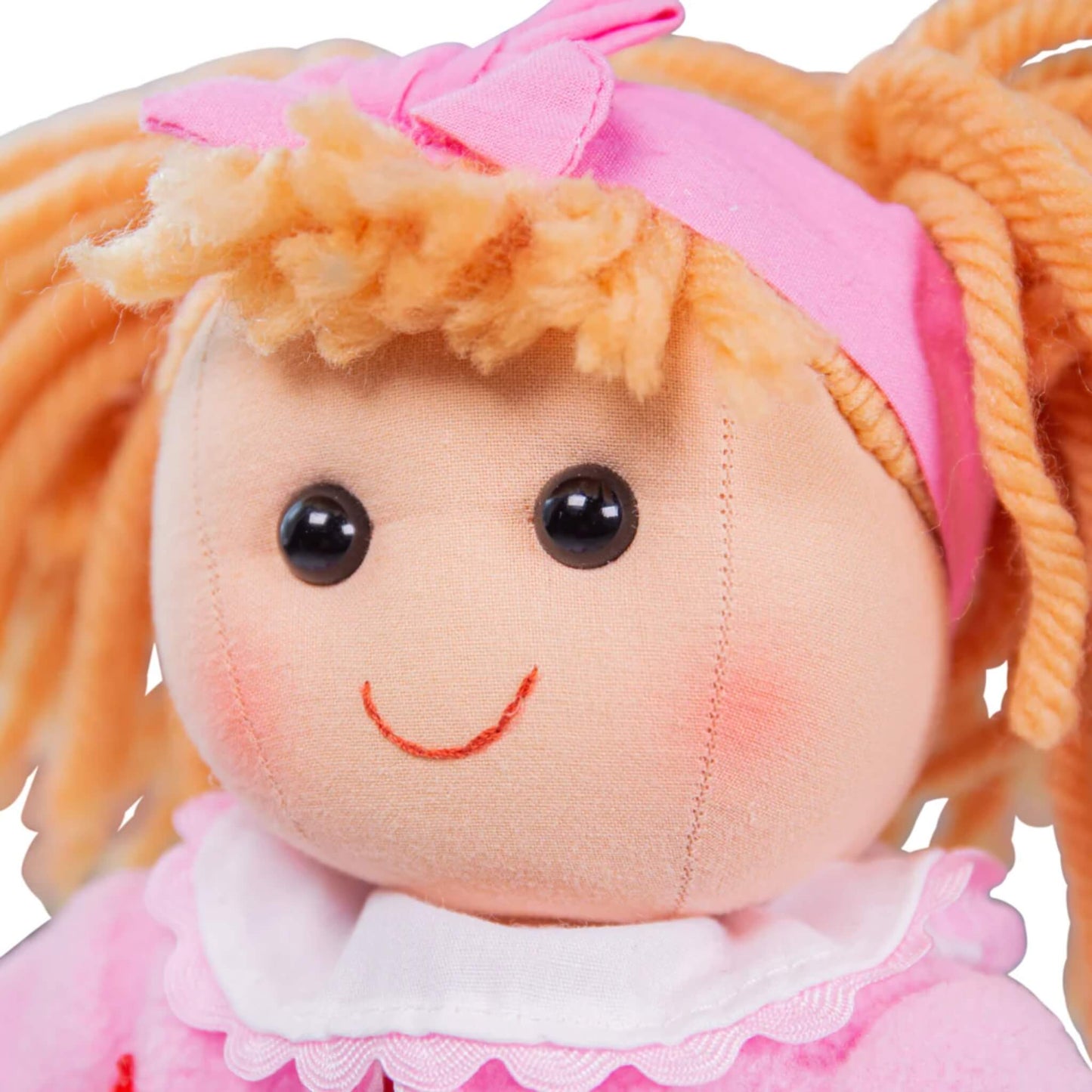 Kelly doll’s sweet smiling face, white frill collar and textured yarn pigtails topped with her bow.