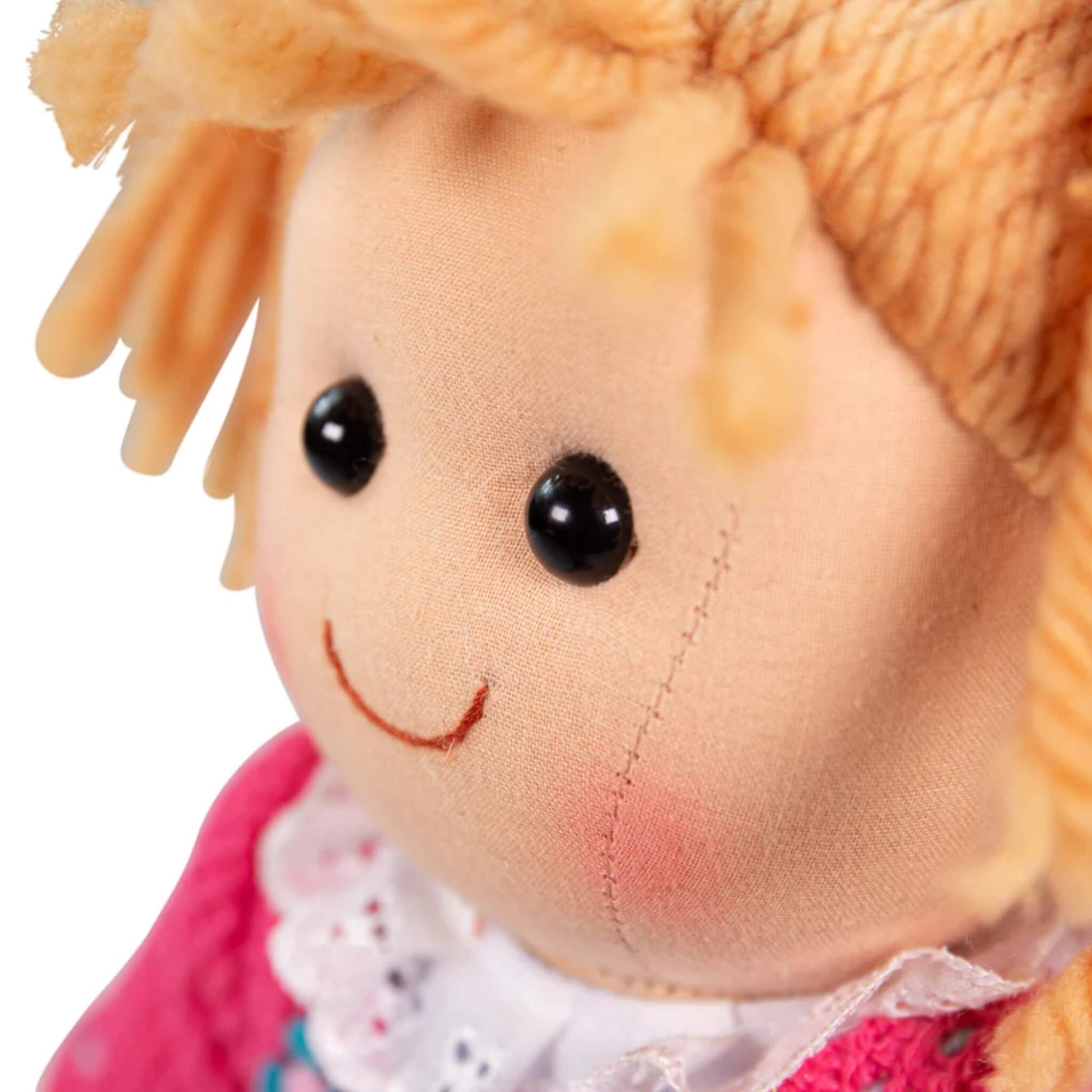 Side profile of Maggie Doll’s face showing soft blush cheeks, black stitched eyes, and sweet smile.