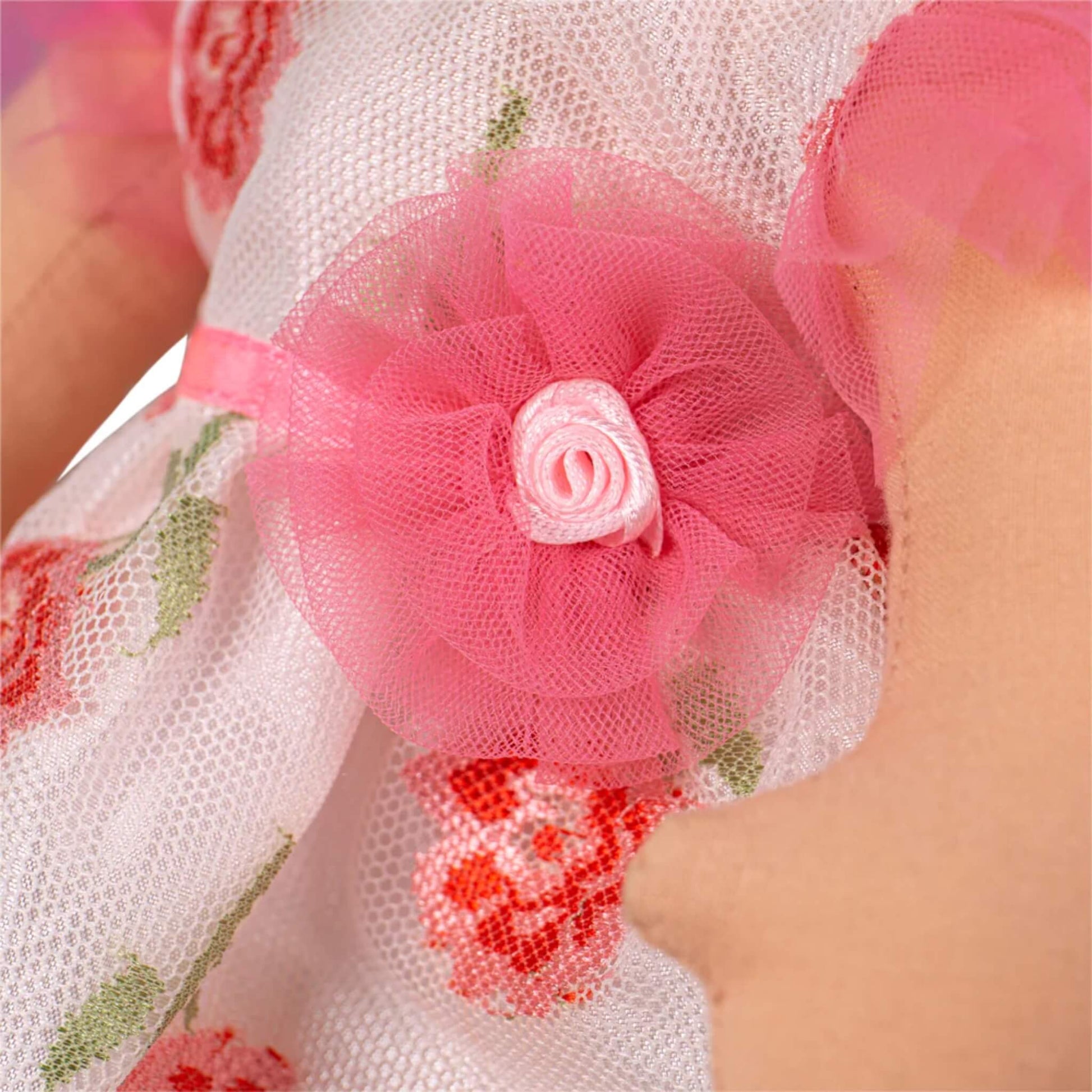 Pink mesh flower with ribbon rose at the waist of the dress.