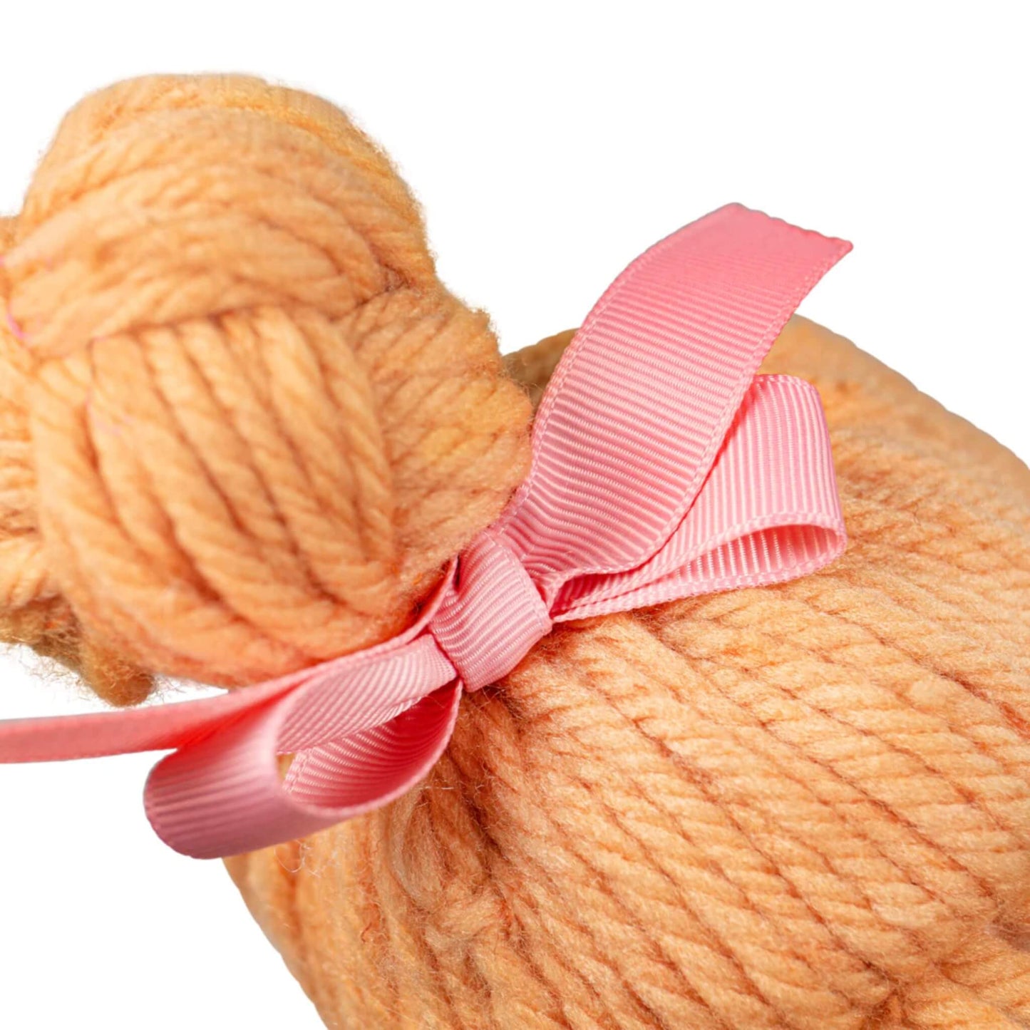 Neatly tied pink grosgrain ribbon on yarn hair bun.