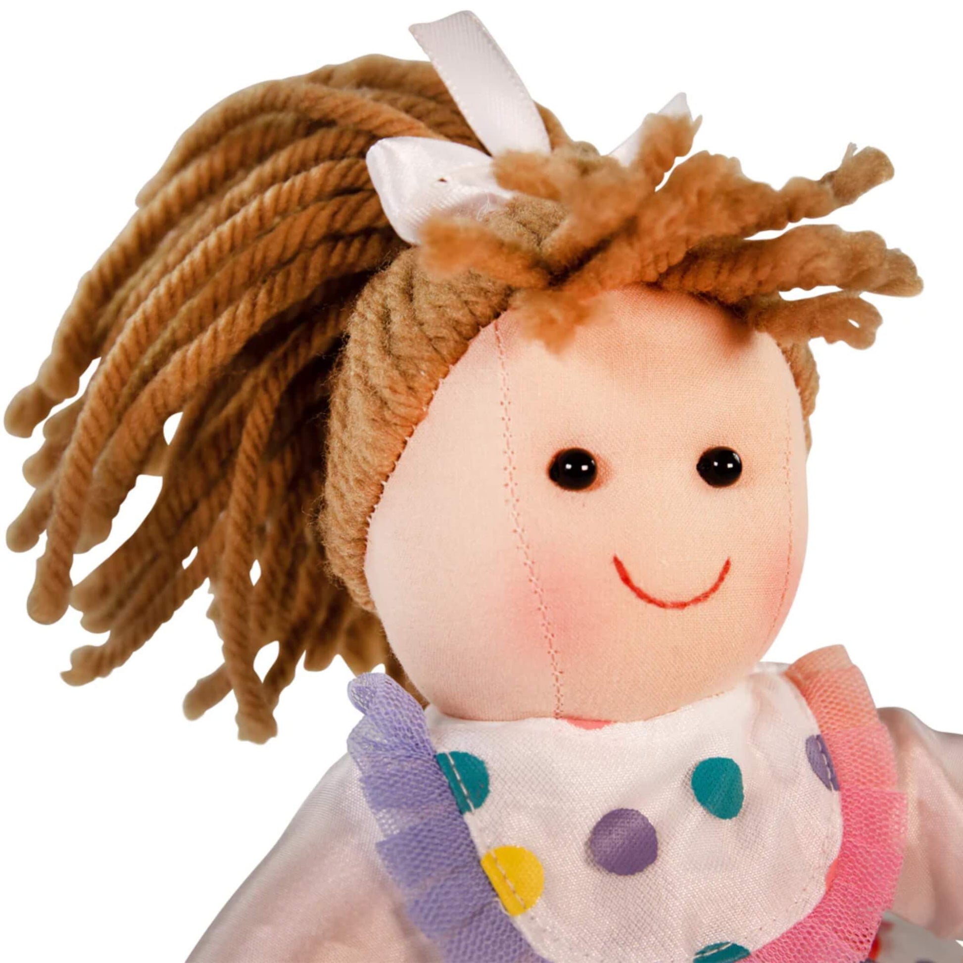 Close-up of the Phoebe Doll’s smiling face and white ribbon in her soft yarn hair.
