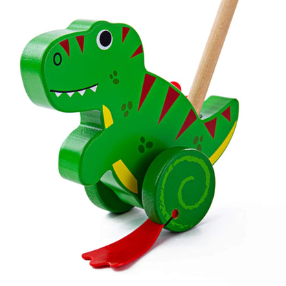 Bigjigs Toys Push Along T-Rex with green wooden body, red painted details, red flapping feet, and a natural wooden handle attached at the back.