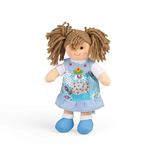 Bigjigs Toys Sarah Doll Small standing upright in a blue patchwork pinafore dress with blue shoes and light brown yarn hair tied in bunches.