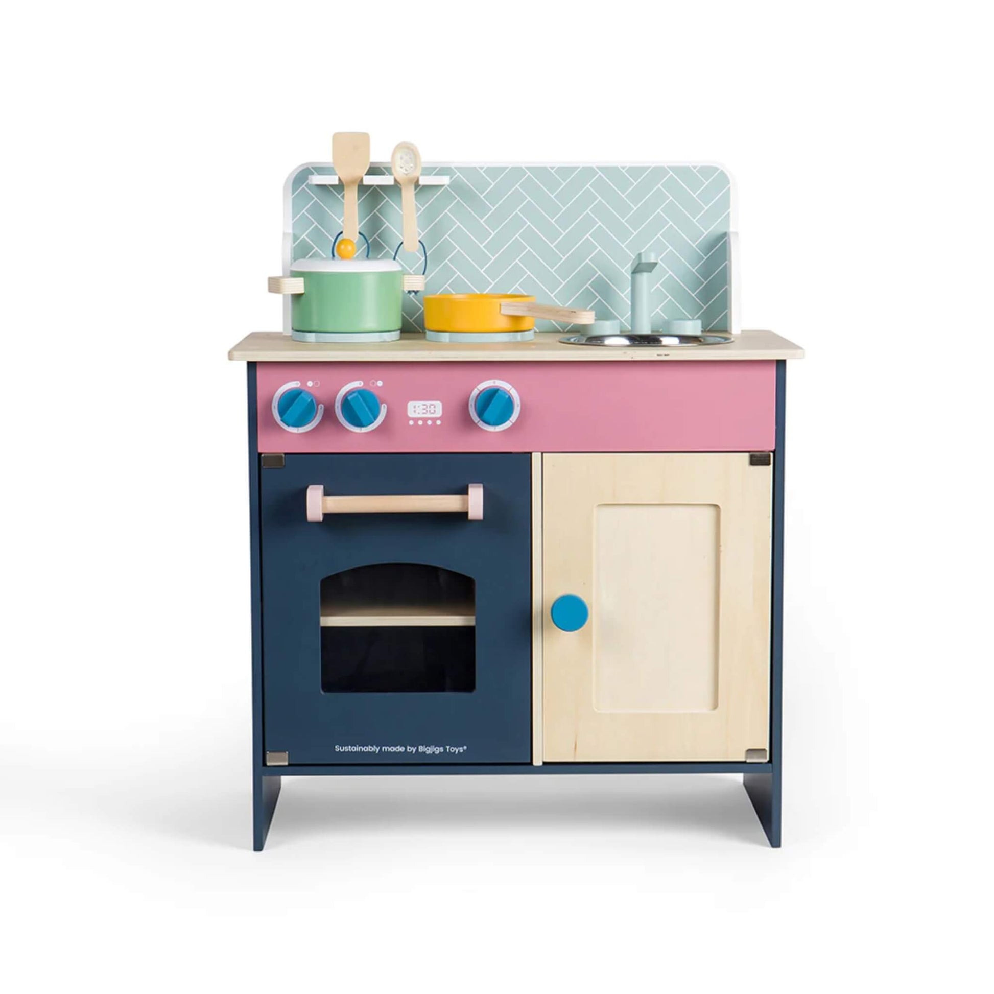 Front view of the Simply Scandi Kitchen showing pink, navy, and cream detailing with wooden knobs and hob dials.