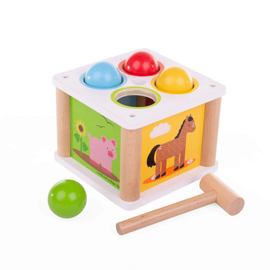 Bigjigs Toys Tap Tap Ball set shown with three colourful balls in matching holes, a wooden hammer, and animal illustrations on the box sides.