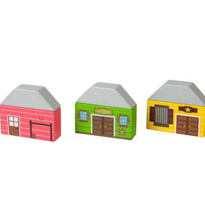 Three wooden Wild West-style buildings from the Bigjigs Toys Wild West Train Set, including a red stable, green store, and yellow sheriff’s office with star emblem.