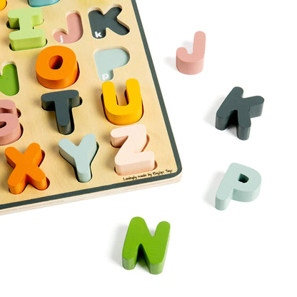 Close-up of pastel wooden letters on the alphabet puzzle, showing matching slots and bright, child-friendly colours.
