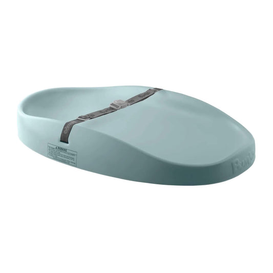 Bumbo changing pad in muted blue with curved sides, wipe-clean surface and adjustable safety strap on a white background.