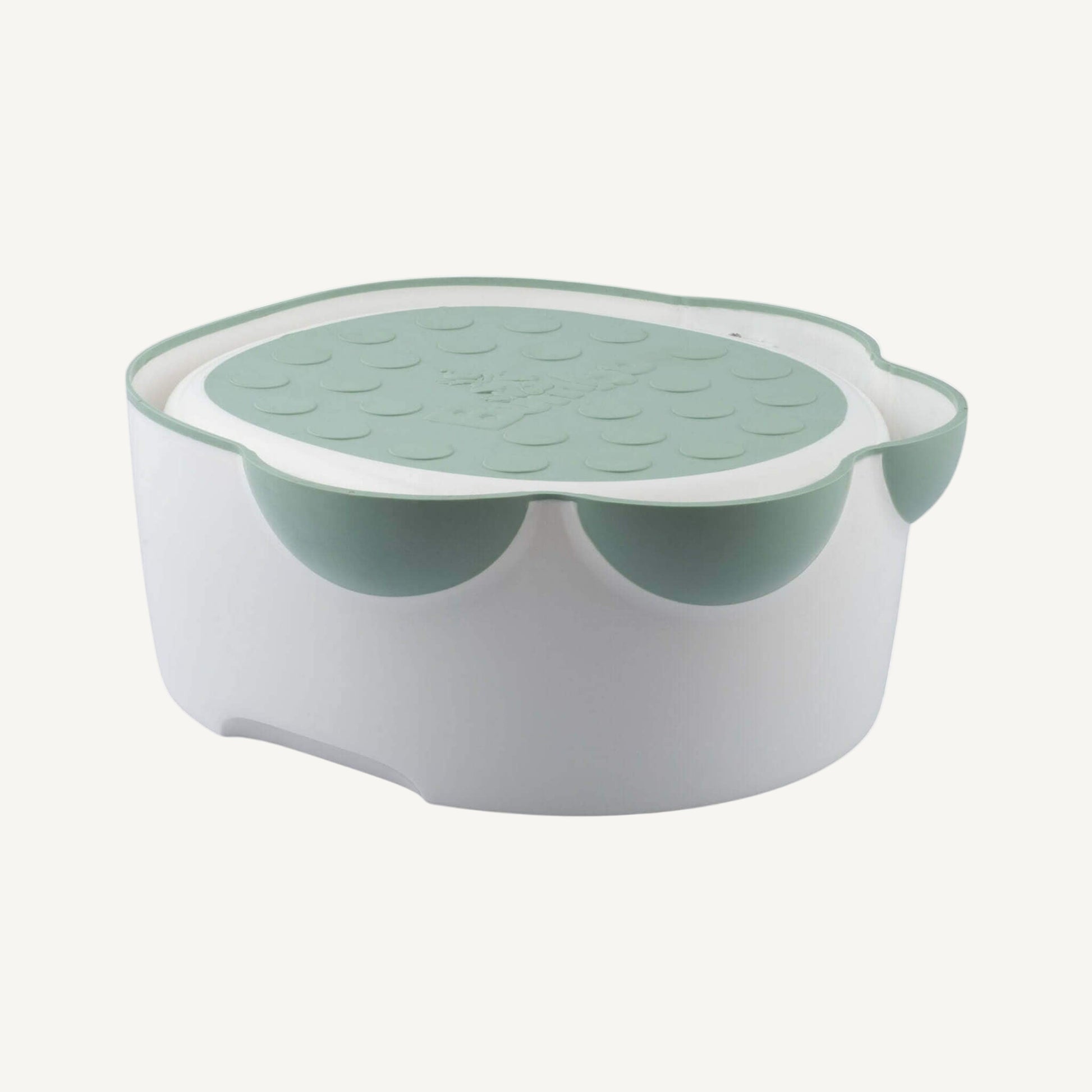 Overhead view of the Step 'n Potty with the lid in place, highlighting the anti-slip surface and curved shape.