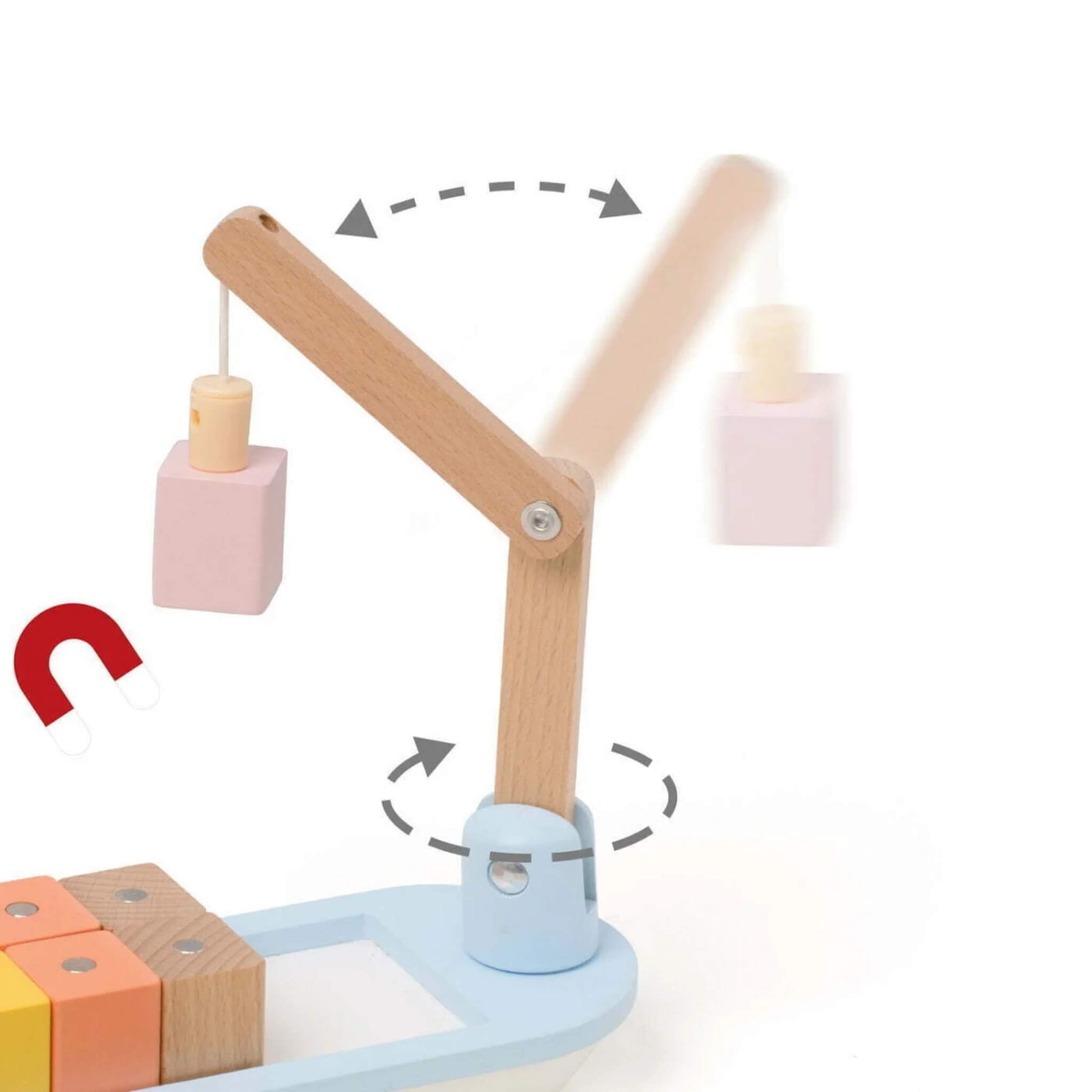 Close-up of a magnetic crane arm lifting a pink wooden block during play.