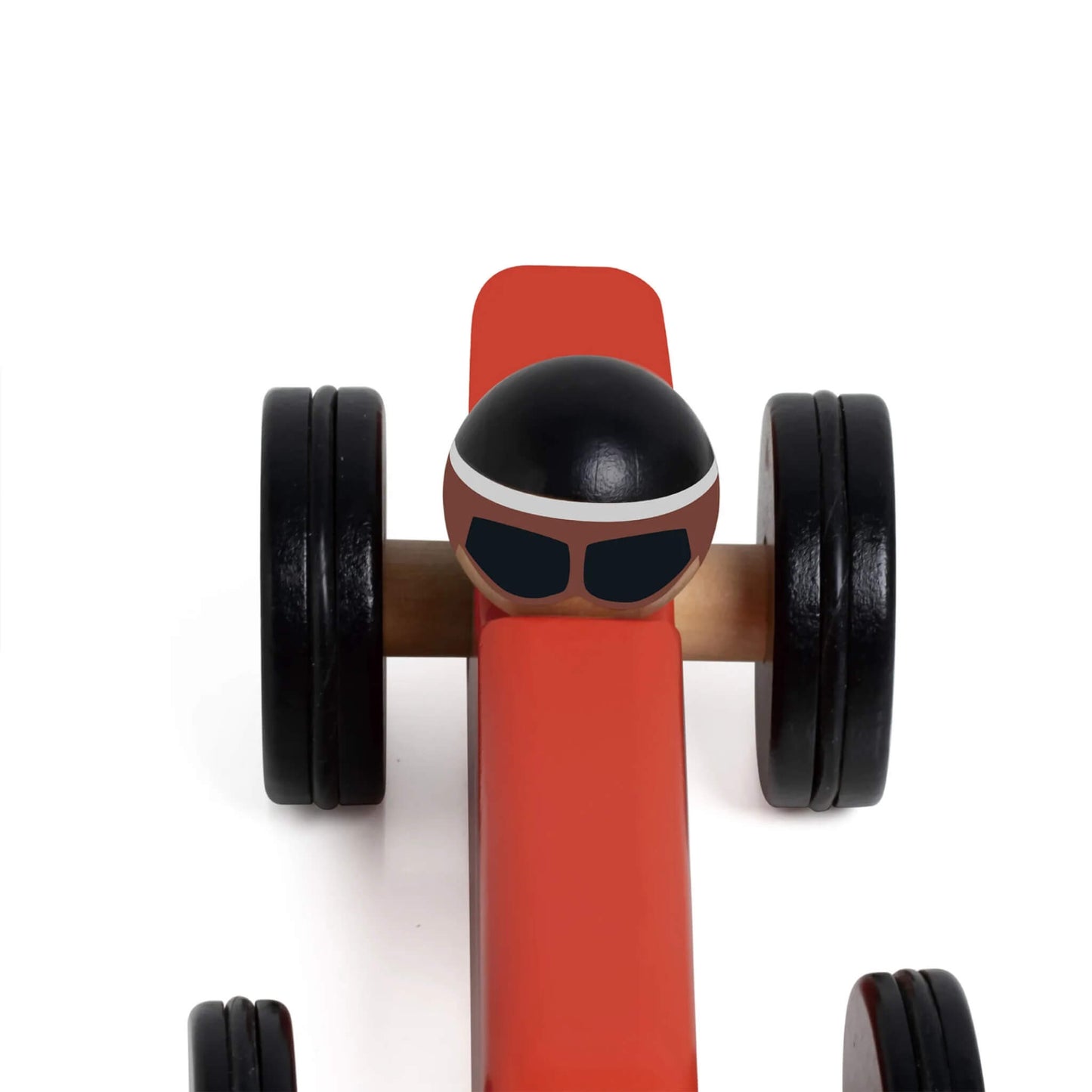 Top view of red Monaco toy race car, showing the wooden driver figure wearing a black helmet and black goggles.