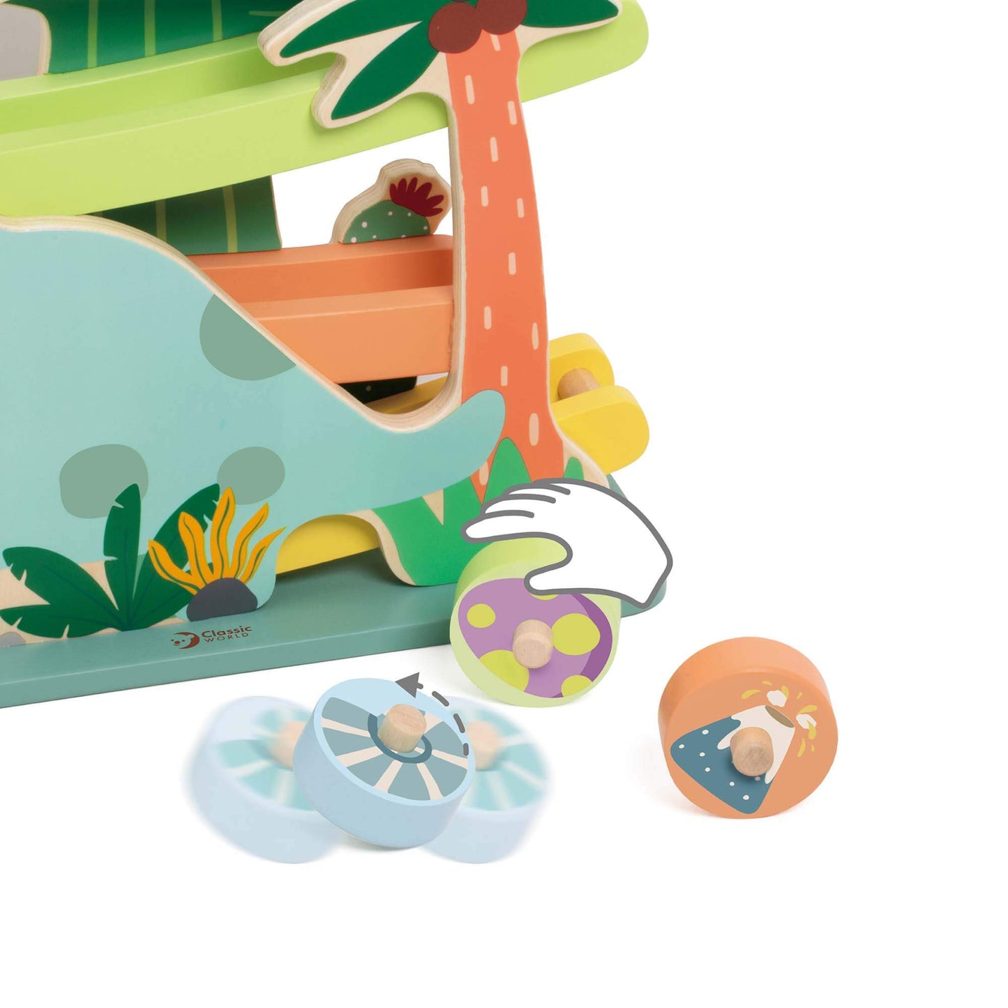 Detail of the dinosaur ramp toy’s base, showing a hand placing a pastel green wooden disc onto the track, with other patterned discs nearby.