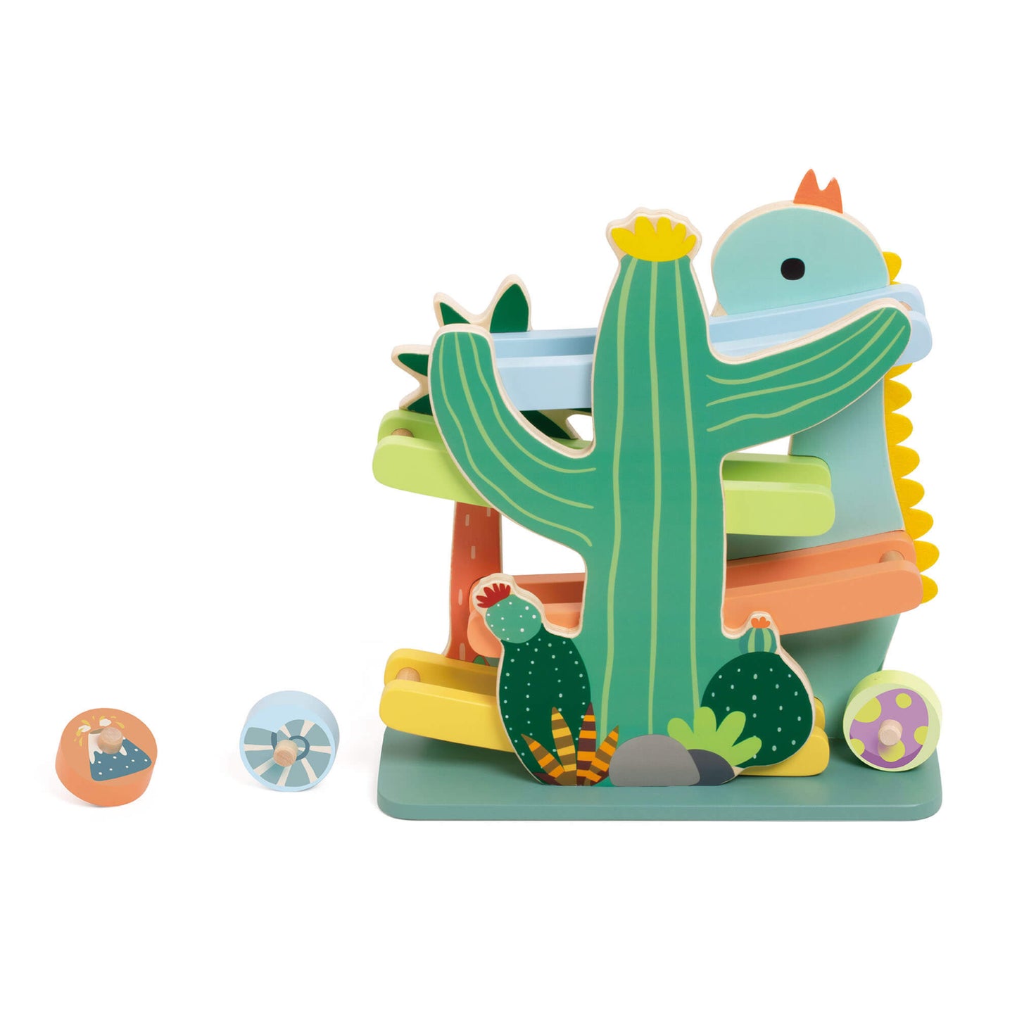 Side view of a wooden dinosaur-themed ramp toy with pastel tracks winding around a cactus and dinosaur figure, with three round patterned rolling discs placed nearby.
