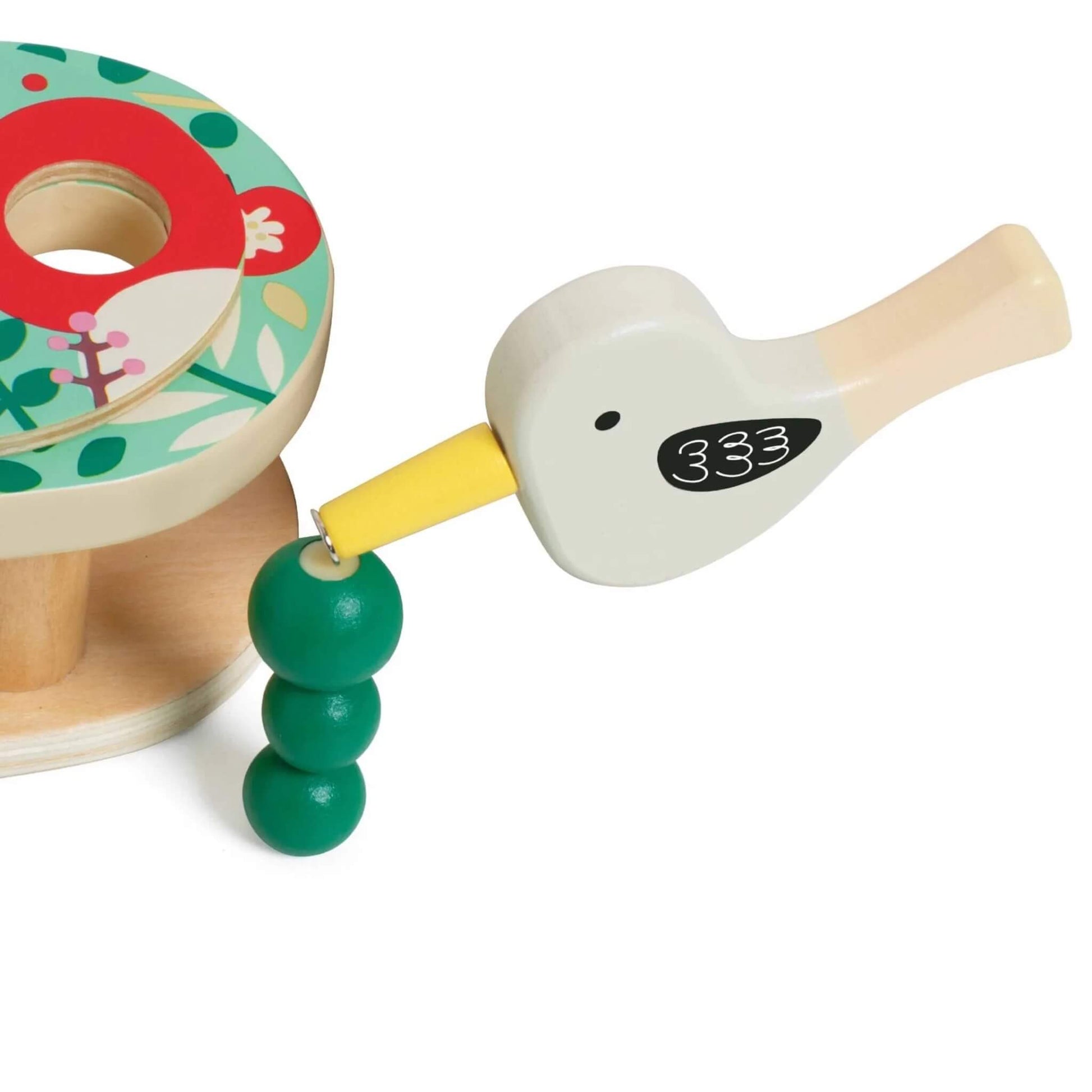 Toy magnetic wooden bird tool picking up a green caterpillar piece, showing the bird’s yellow beak attached to the caterpillar bead.