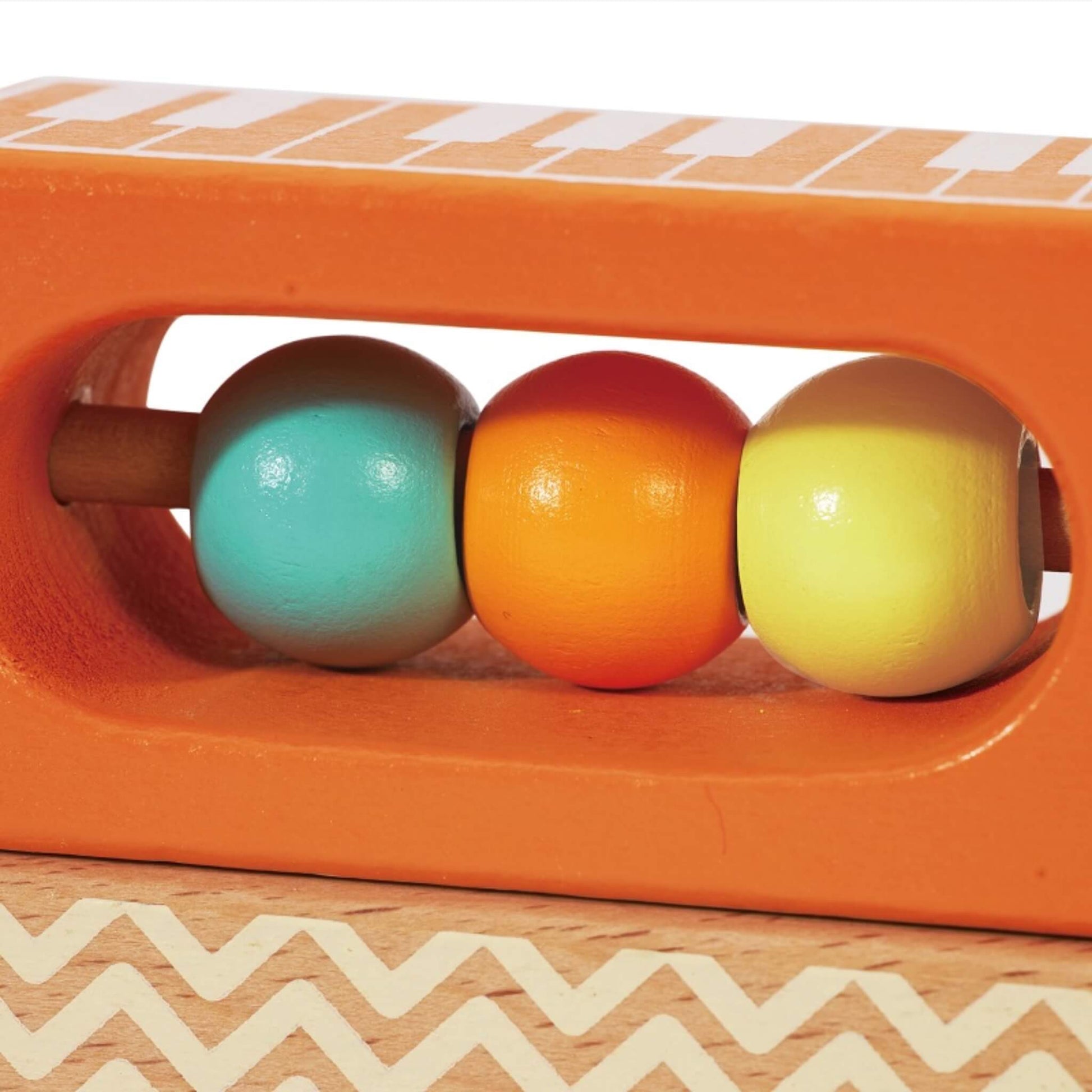 A close-up of a rectangular wooden block with three painted beads sliding along a fixed rod inside an orange frame.