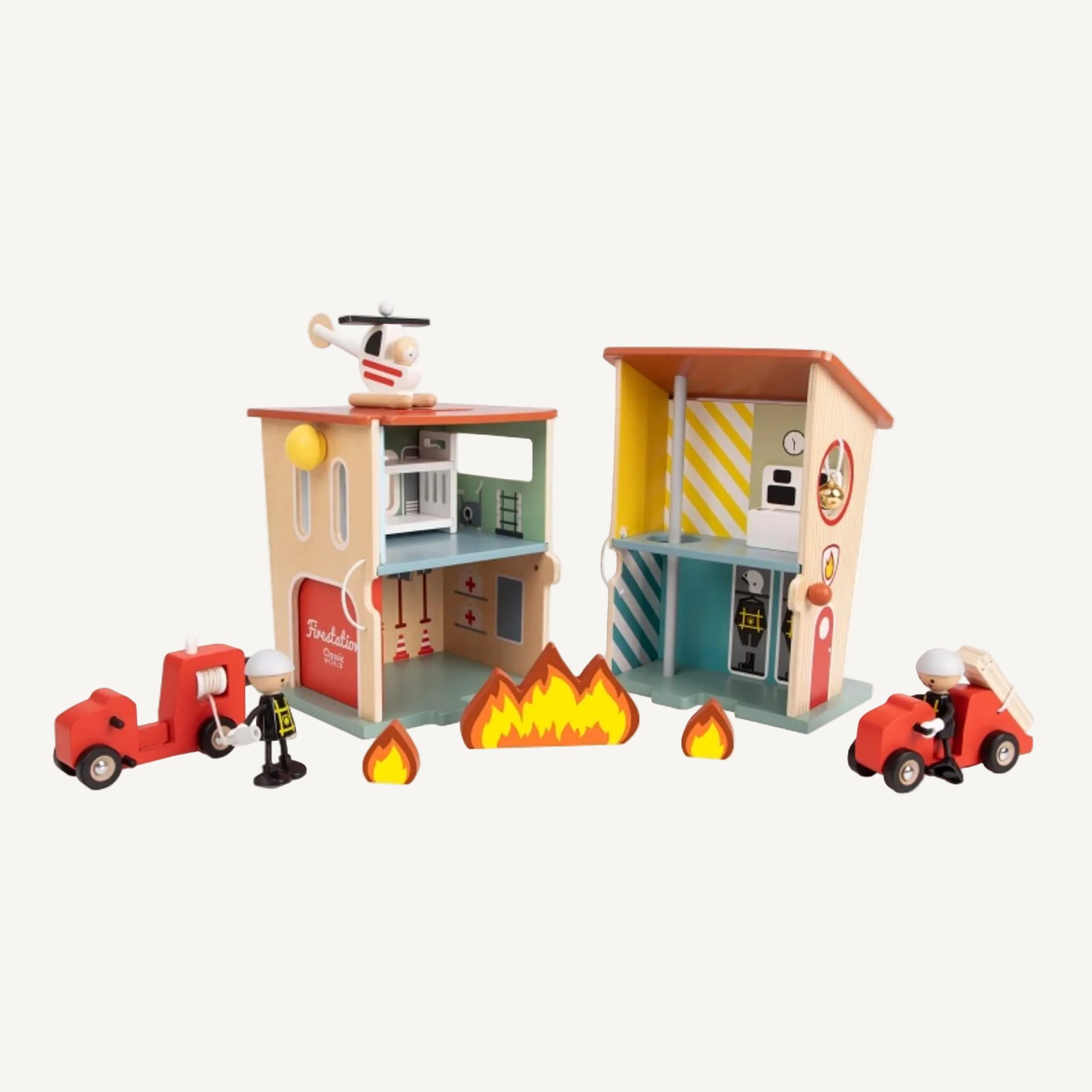 A wooden fire station play set opened out to show interior rooms with vehicles, firefighter figures and flame pieces arranged in front.