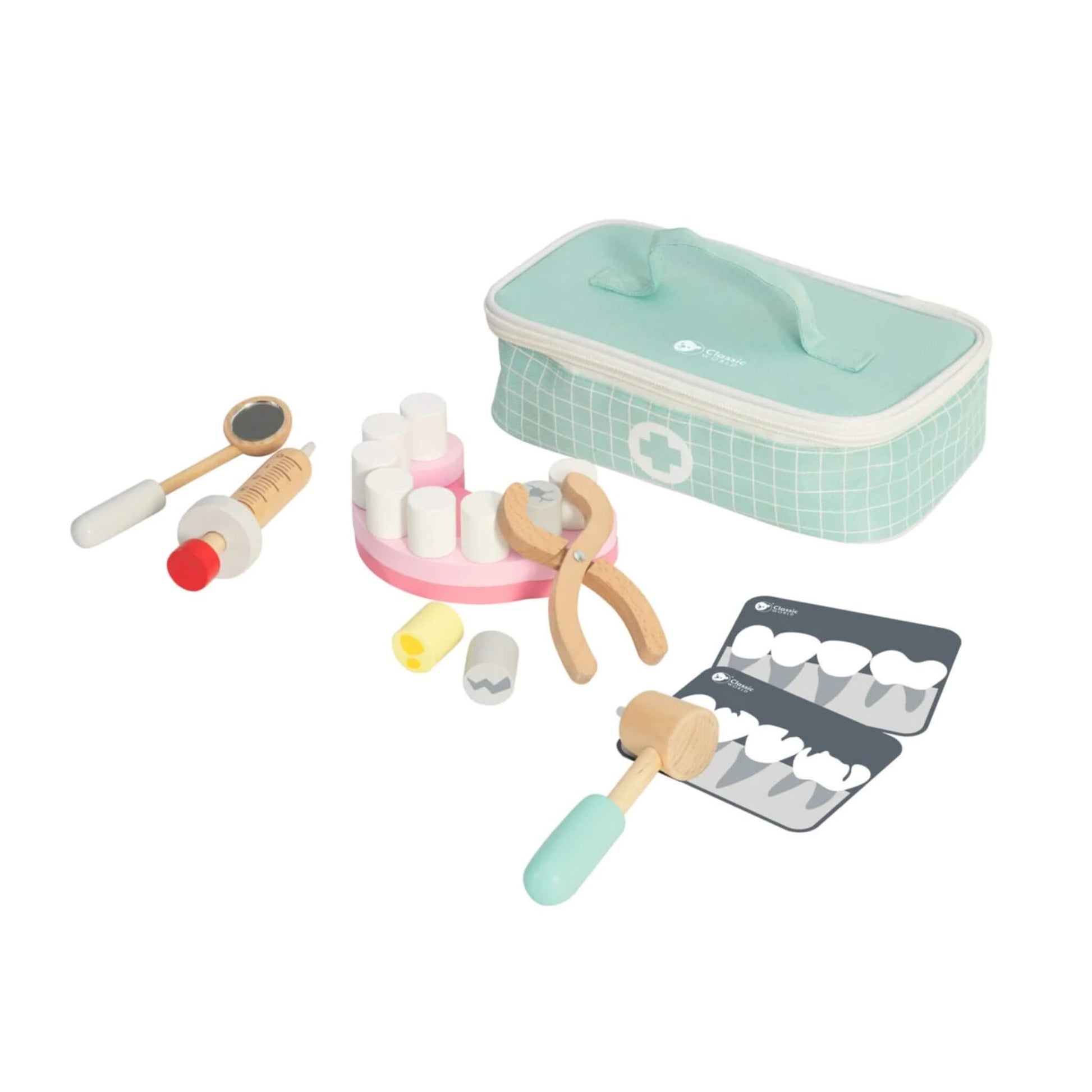 A pastel green carry case holds the Classic World Little Dentist Set, shown beside it are wooden dental tools, a pink tooth model, X-ray cards, and play accessories.