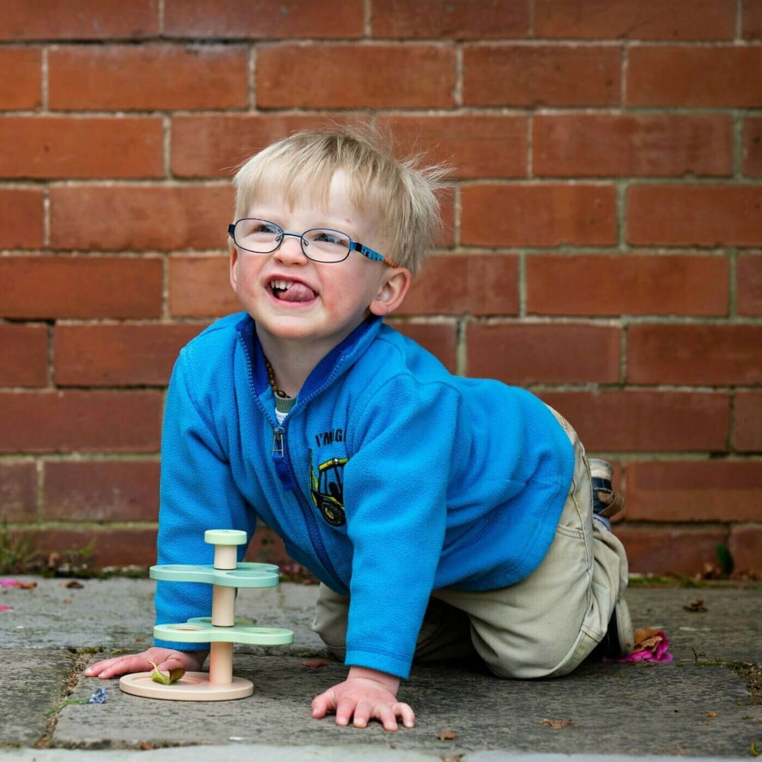 A cheerful child smiles while playing outdoors with a Natural World Exploration set.