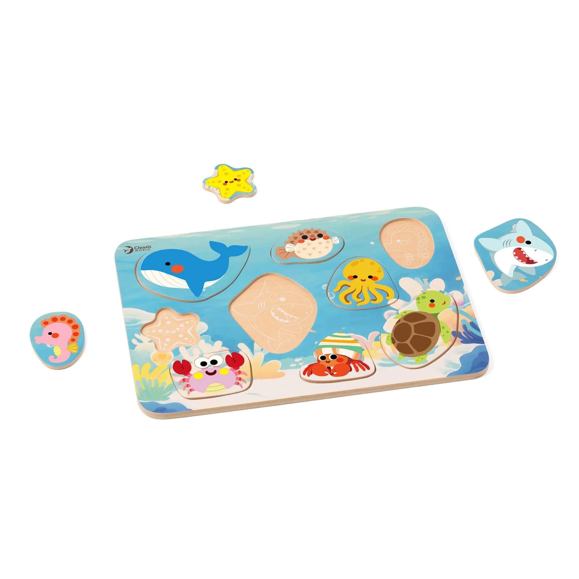 Wooden ocean puzzle board with several sea creature pieces removed, showing matching outlines; includes starfish, crab, turtle, seahorse, octopus, shark, whale, and pufferfish on a blue background with coral illustrations.