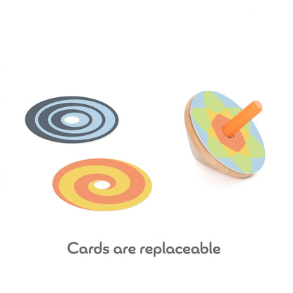 Wooden spinning top with a geometric pattern and two additional spiral design discs shown beside it, illustrating how the cards can be replaced.