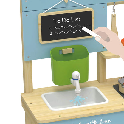 Close-up of a blackboard with “To Do List” written on it, a hand holding white chalk, and a green bucket with a working tap splashing water into the sink below.