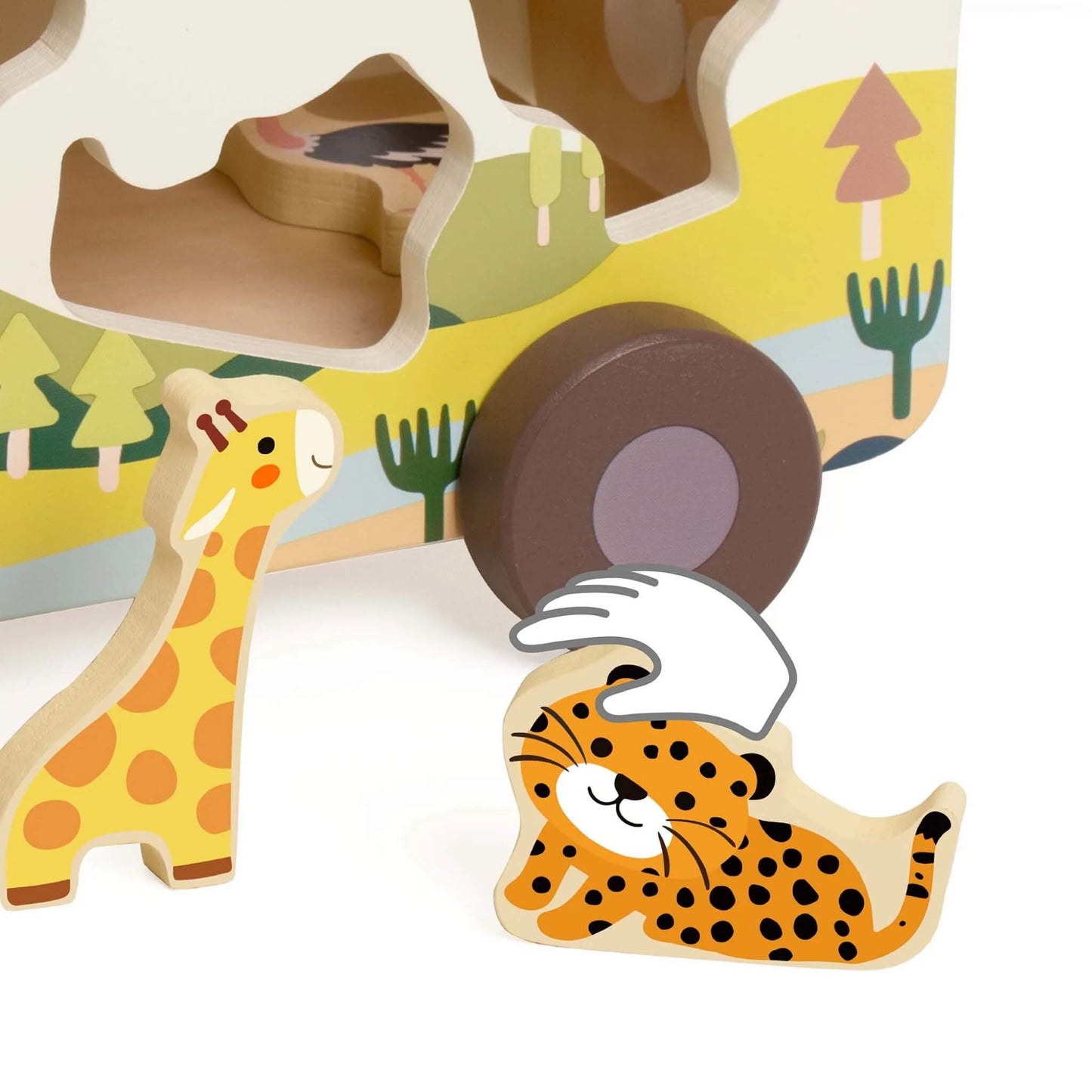 Zoomed-in view of a wooden giraffe and leopard figure beside the truck, with a hand shape indicating interactive play.