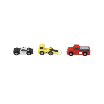 Side view of three wooden toy service vehicles lined up — black and white police car, yellow tow truck with hook, and red fire truck.
