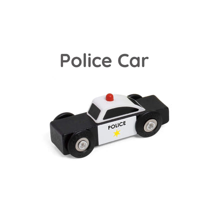Close-up of black and white wooden toy police car with red light on top and star badge detail on the side.