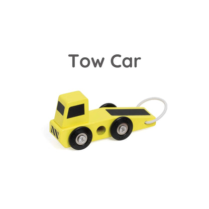 Close-up of yellow wooden toy tow truck with black details and a small white hook at the back.