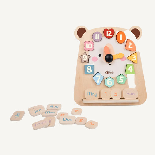 Wooden educational clock toy with removable number shapes and date tiles arranged around a bear face design on a neutral background.