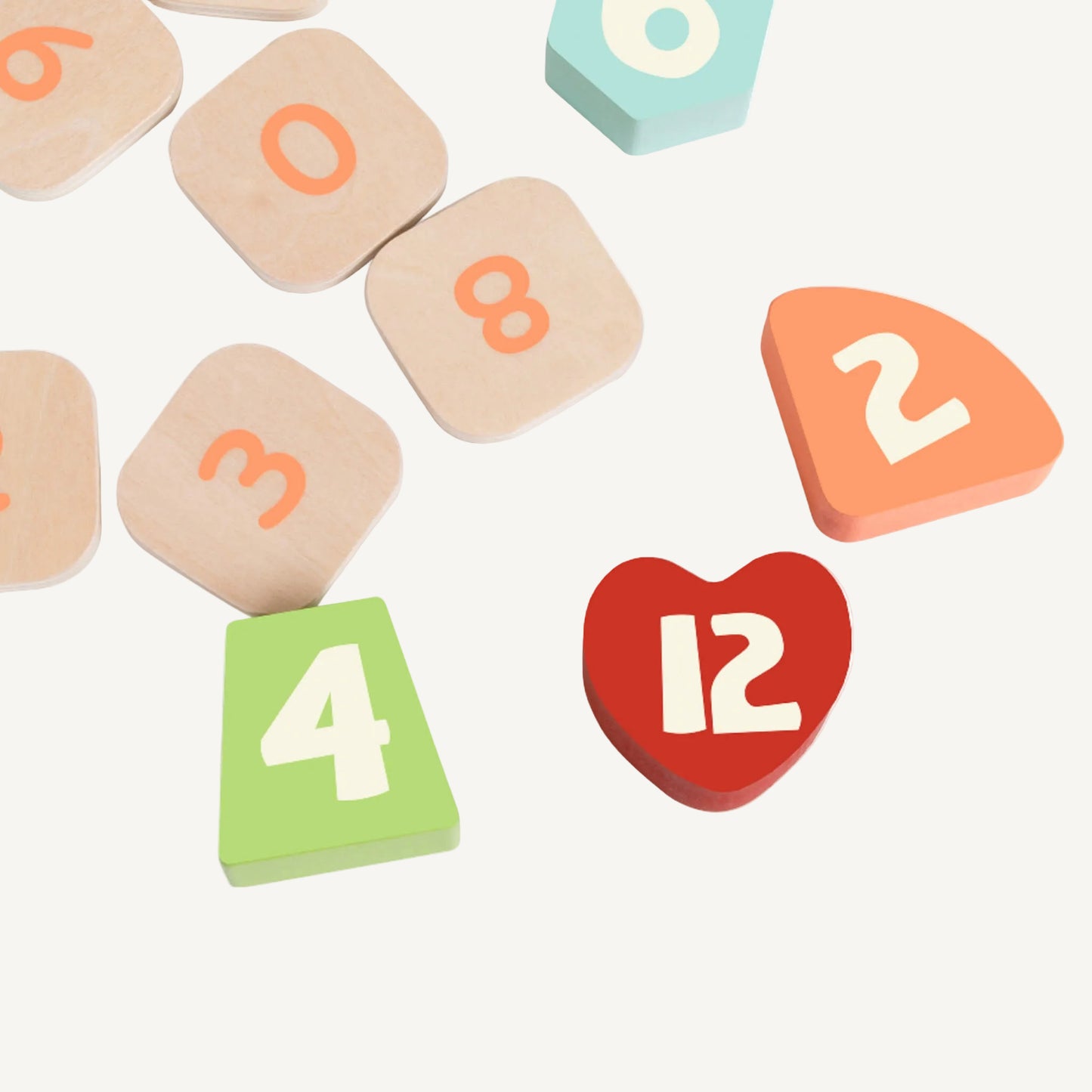 Wooden number and shape pieces from a children’s learning clock toy scattered on surface showing tactile educational elements.