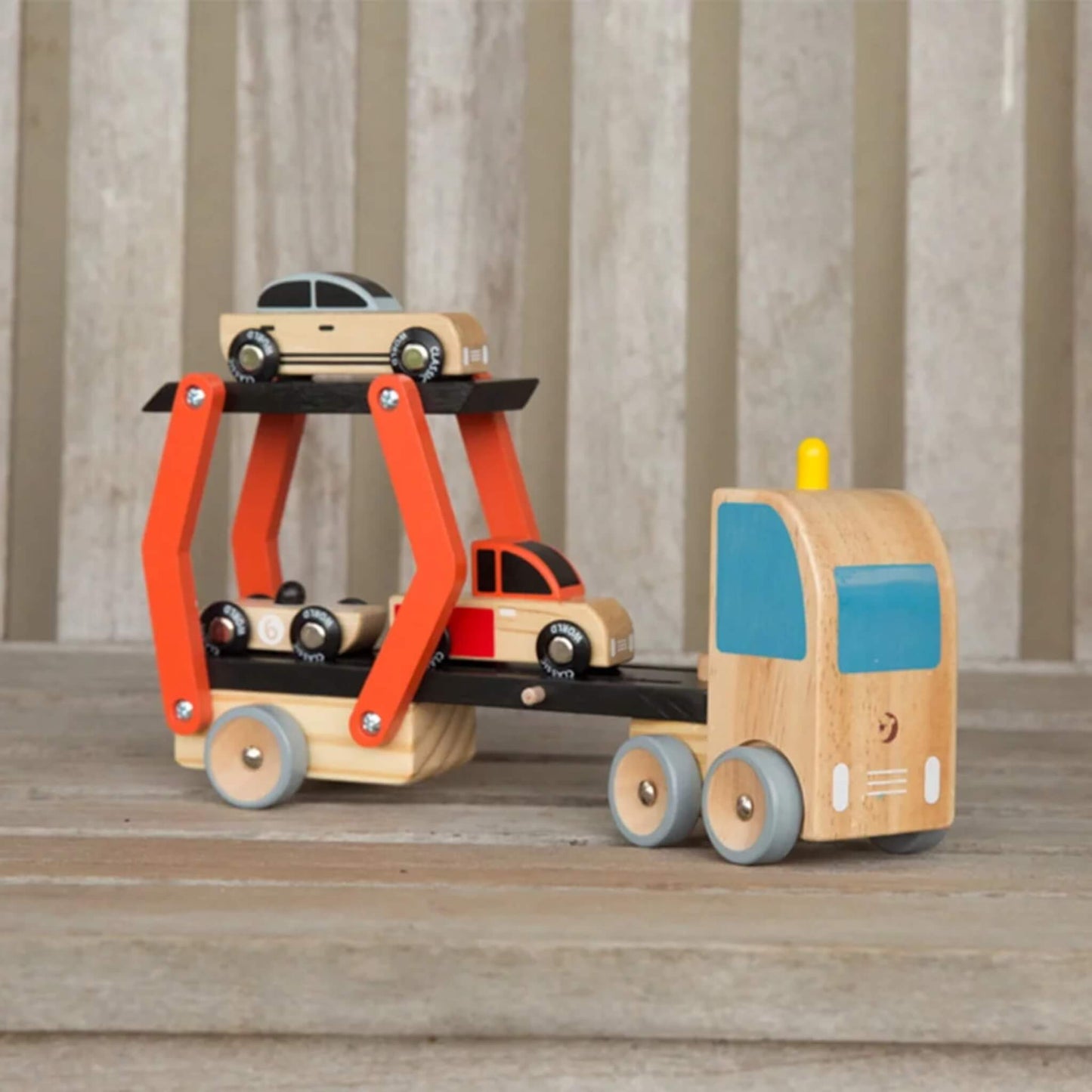 Wooden toy car transporter with adjustable ramp, holding three small toy cars on two levels.