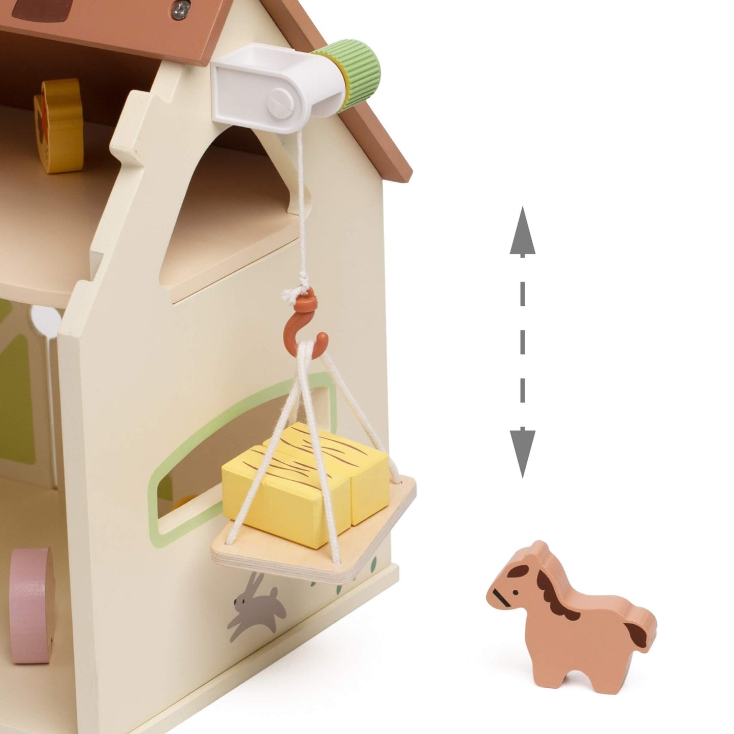 Close-up of wooden farm playset pulley system lifting hay bale with turning handle feature.