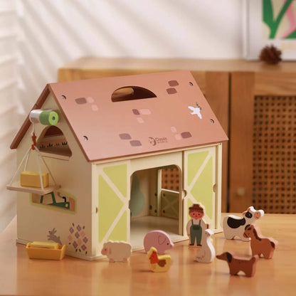 Wooden vintage farm playset styled on table with barn, animals and accessories arranged for play.