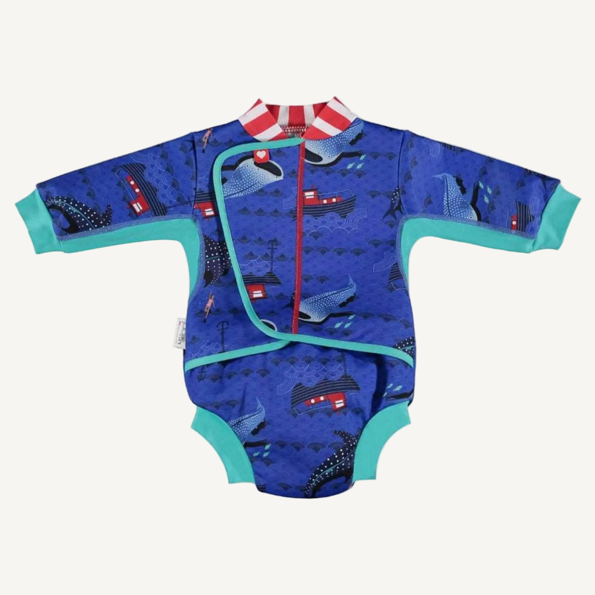A long-sleeved baby cosy suit laid flat with teal cuffs, a blue ocean-themed whale shark print and a front wrap-style opening.