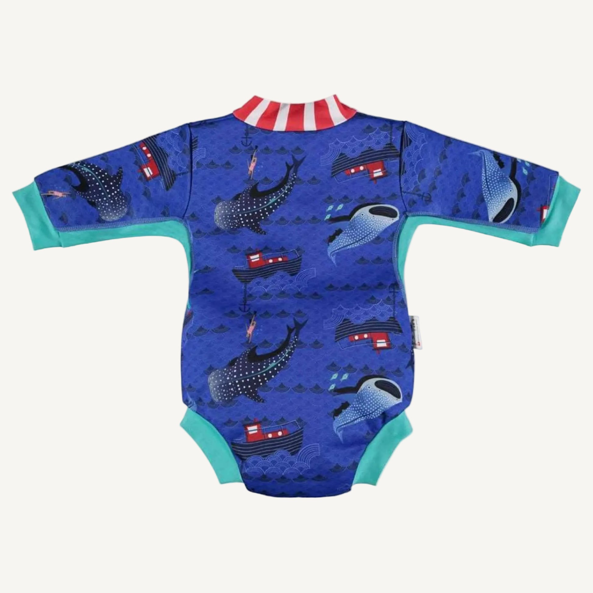 A baby cosy suit shown from the back with long sleeves, teal cuffs and a blue ocean-themed whale shark print featuring boats and waves.