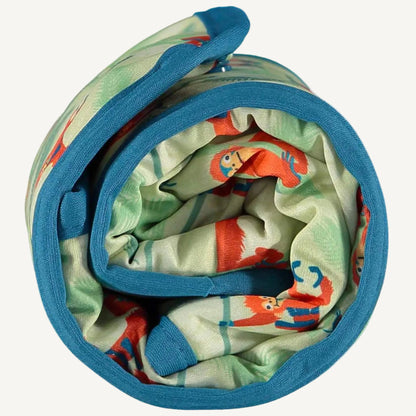 A rolled changing mat shown from above, displaying the soft fabric layers and the bright orangutan print gathered inside.