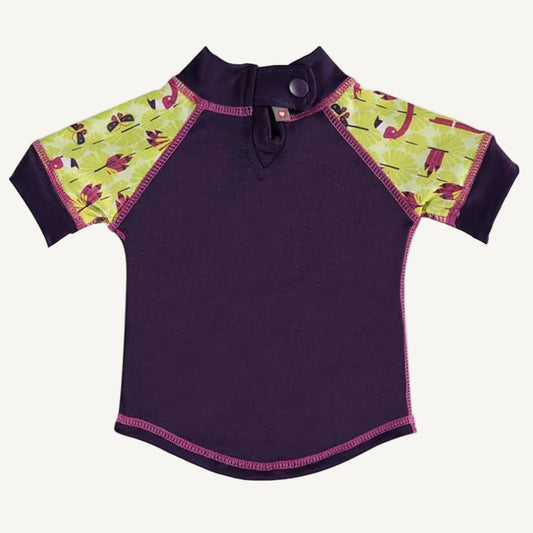 A short-sleeved rash vest shown from the back with a purple body, patterned yellow-and-pink sleeves and a single popper fastening at the neck.