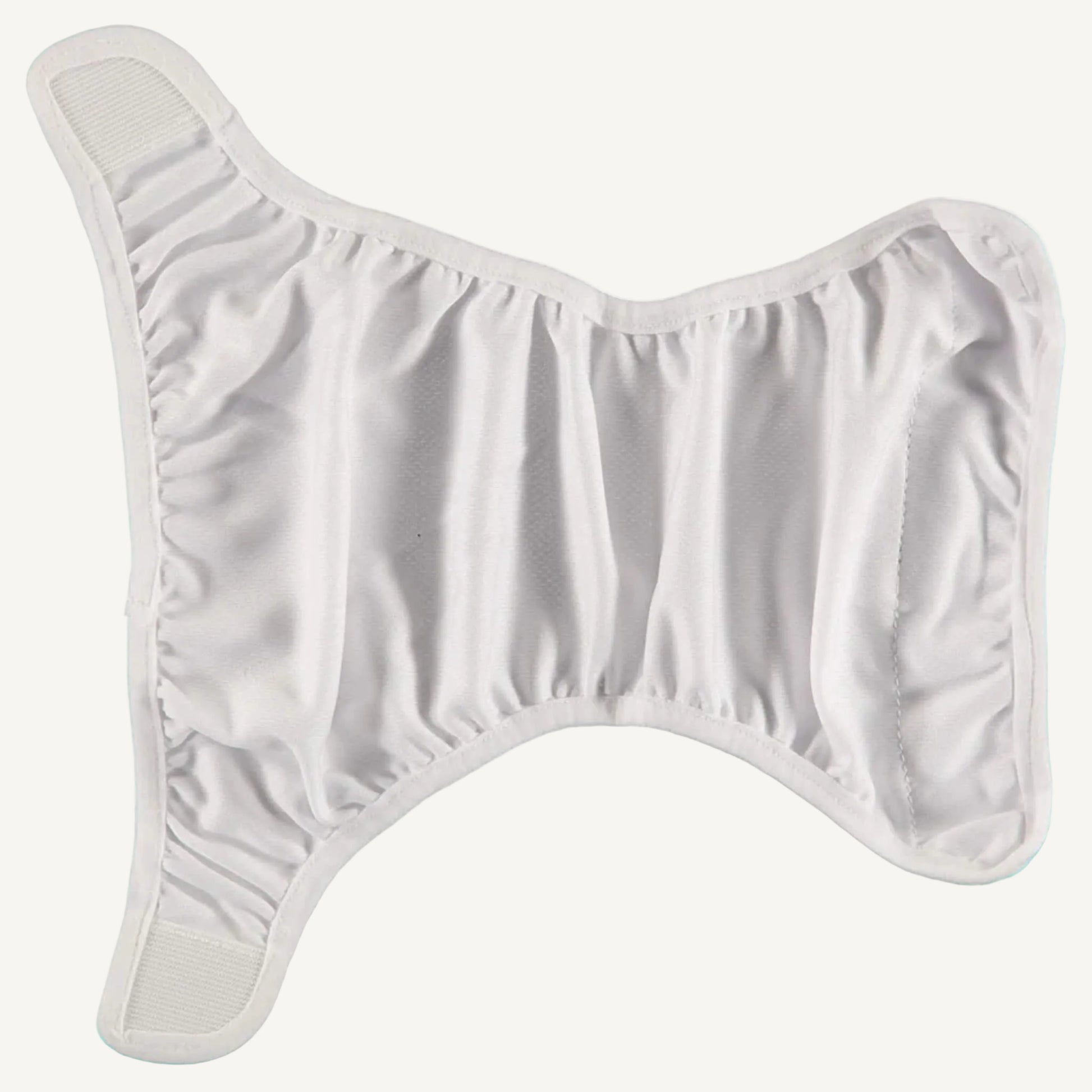 A white swim nappy liner laid completely flat to show the inner panel, featuring soft fabric, curved shaping around the legs and arms, and elasticated edges that create a close fit when fastened.