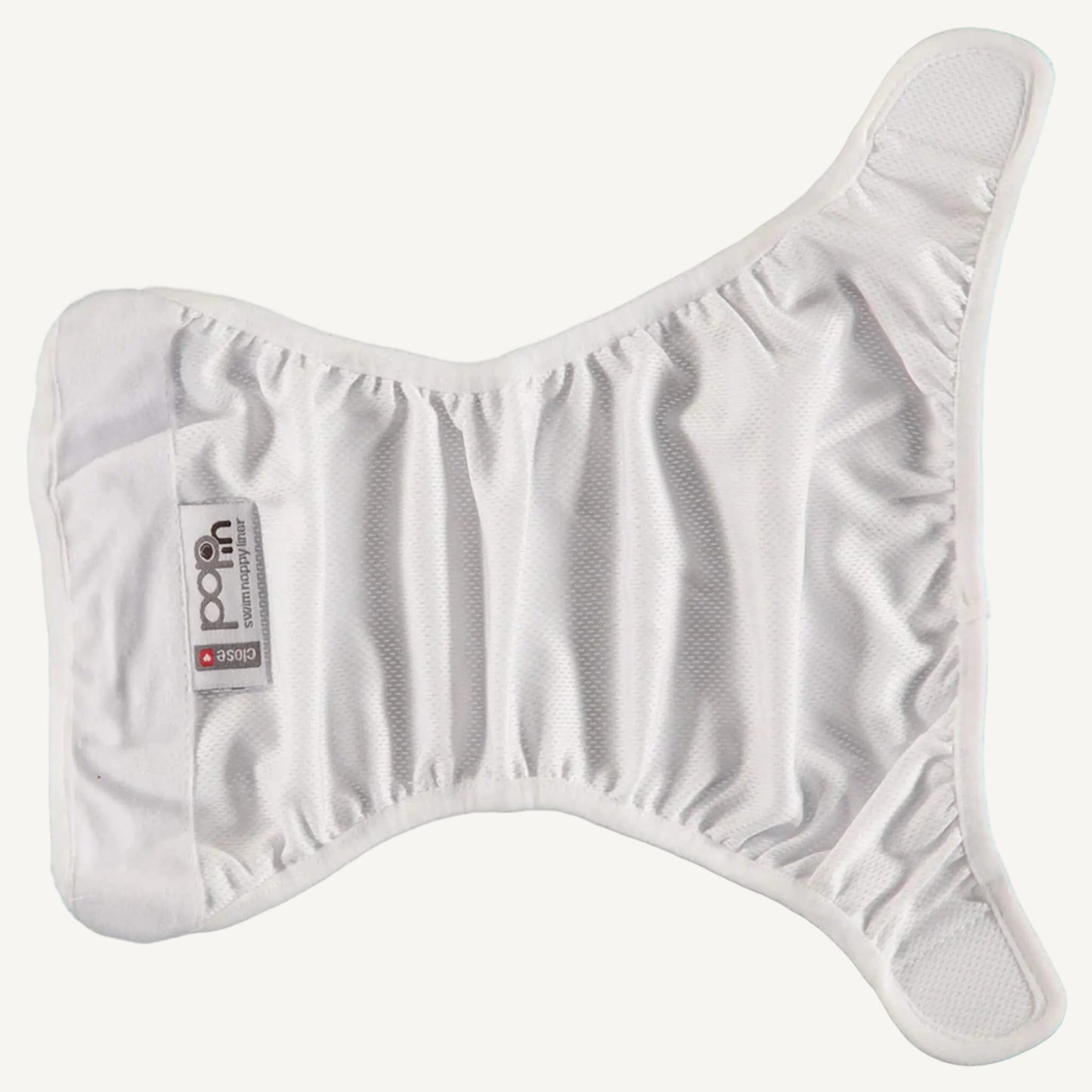 A white swim nappy liner laid open in a butterfly shape, showing the gathered elastic around the leg areas and the smooth inner fabric designed to sit against the skin.