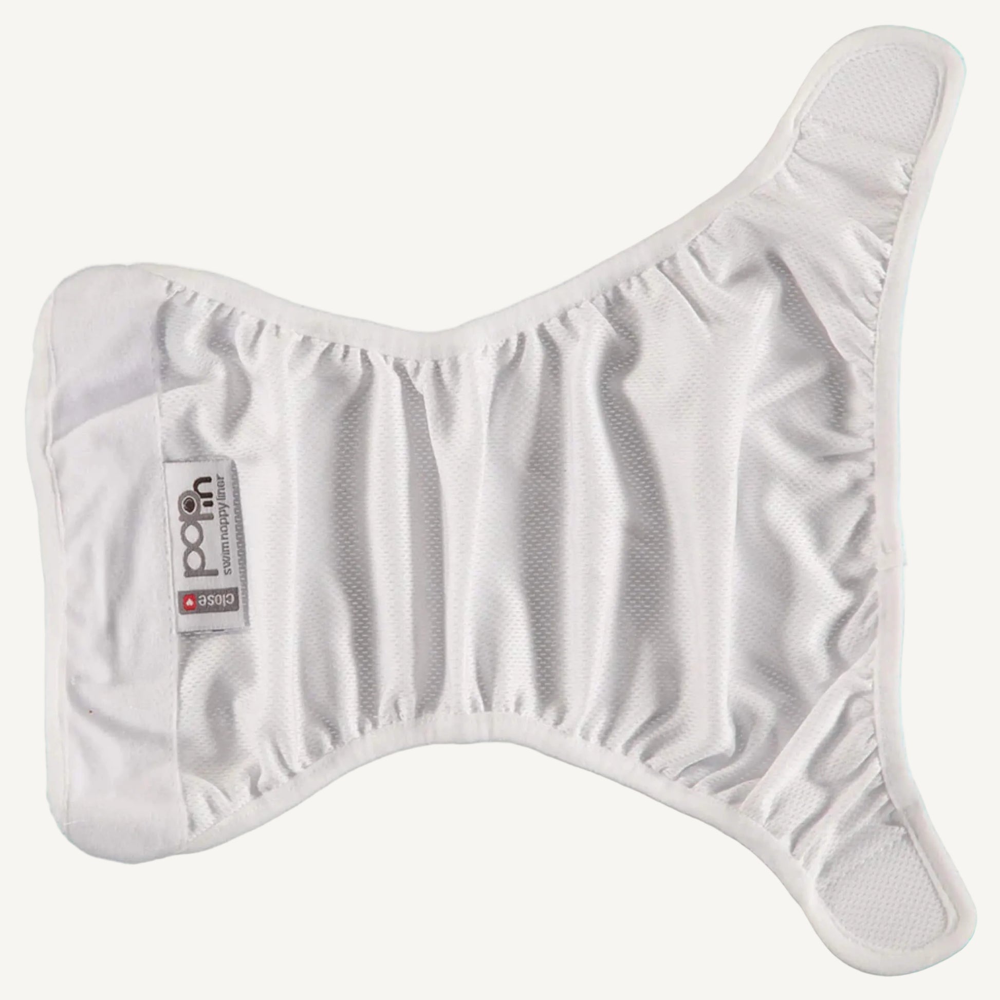 A white swim nappy liner laid open in a butterfly shape, showing the gathered elastic around the leg areas and the smooth inner fabric designed to sit against the skin.