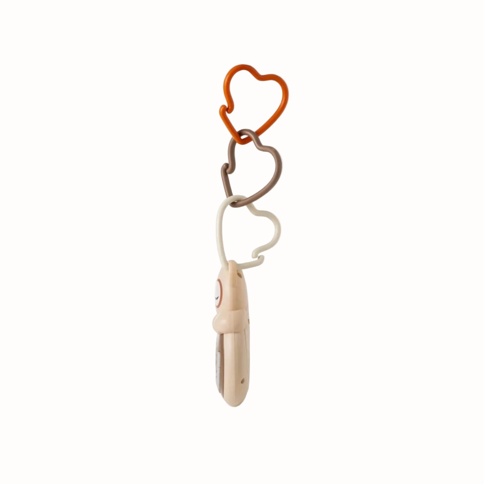 Side view of an owl-shaped portable baby sound machine showing its slim profile and attachment links