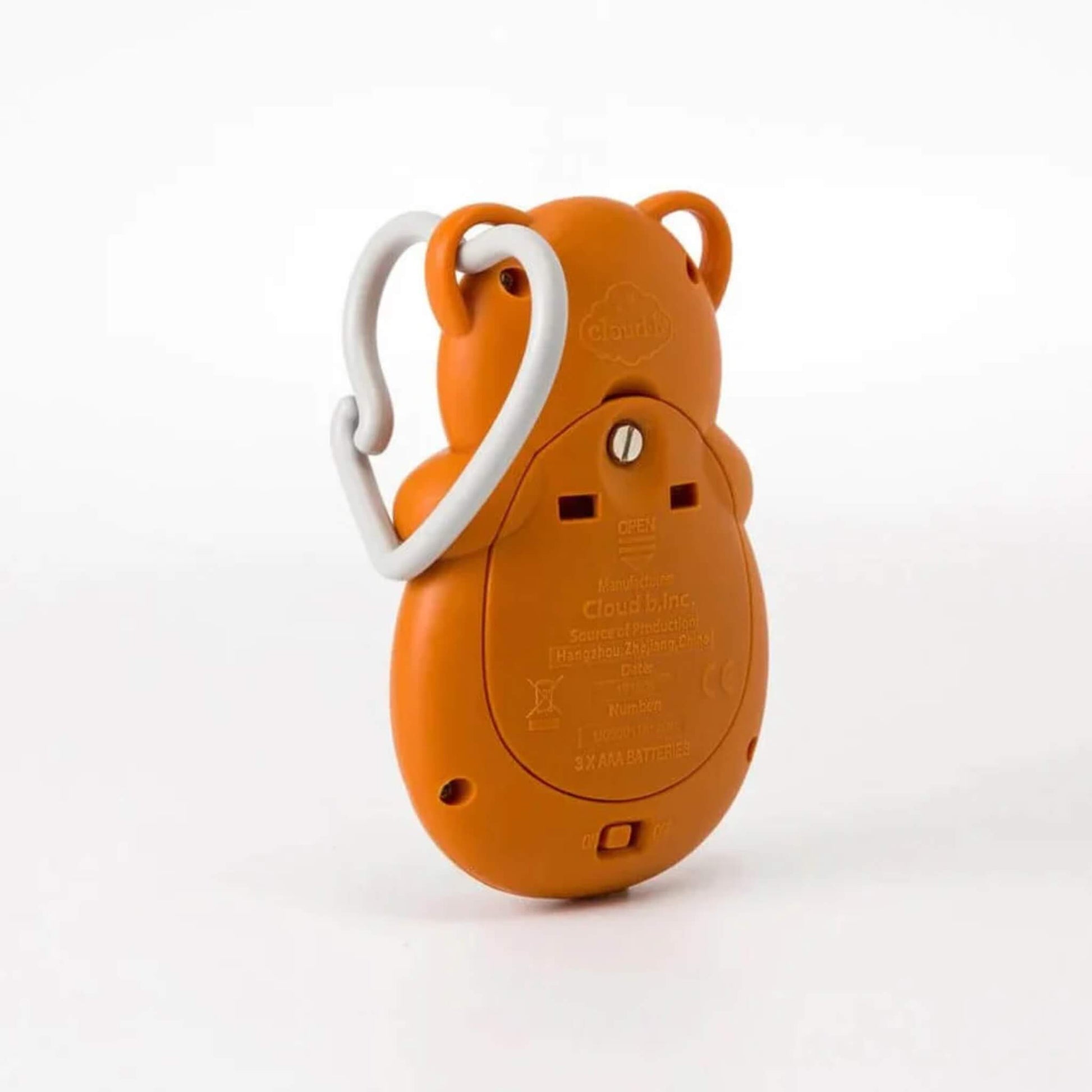 Back view of the fox-shaped sleep aid in orange, showing the battery compartment and labelled details along with the grey heart-shaped clip.