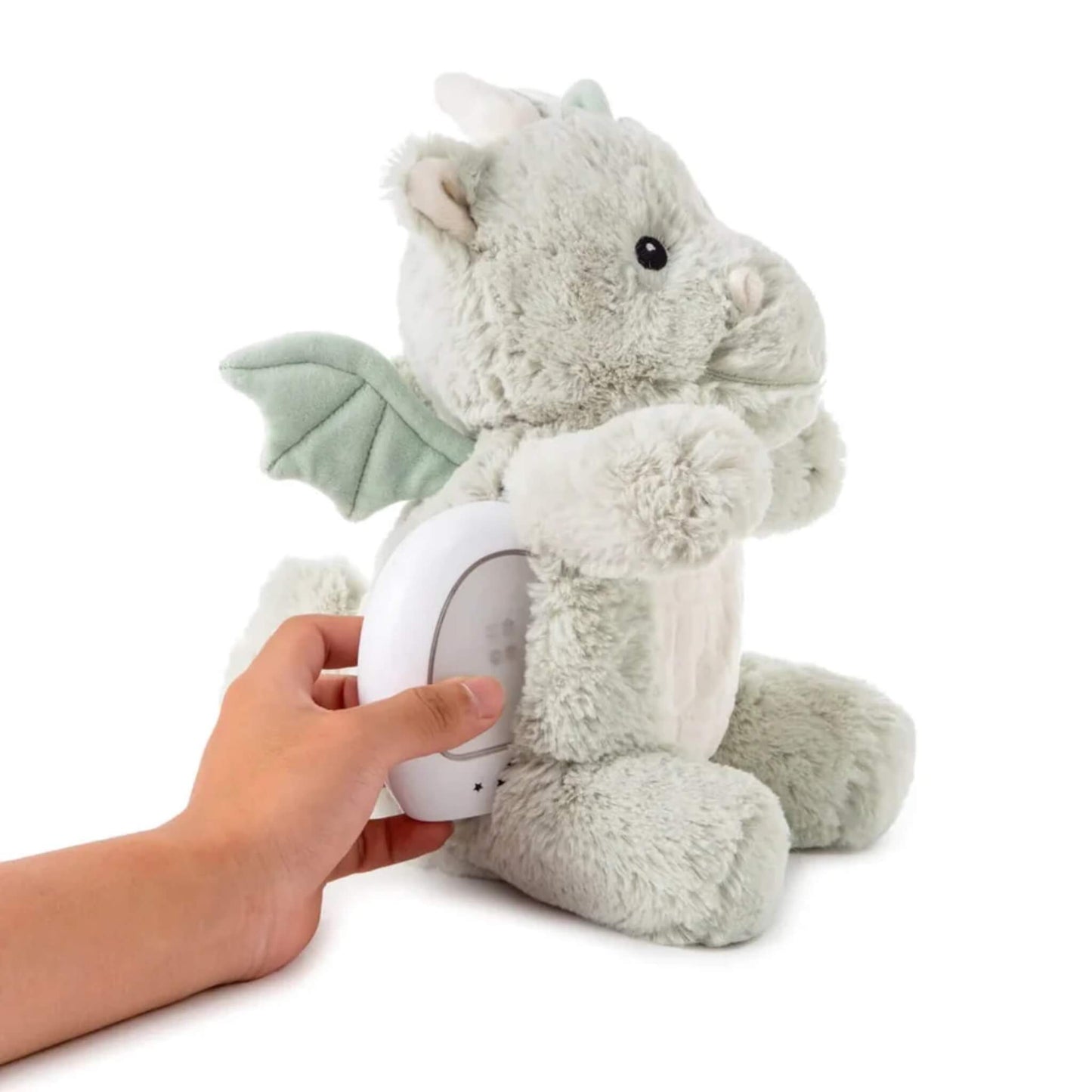 A hand is shown inserting the small white nightlight unit into the back of the plush dragon toy.