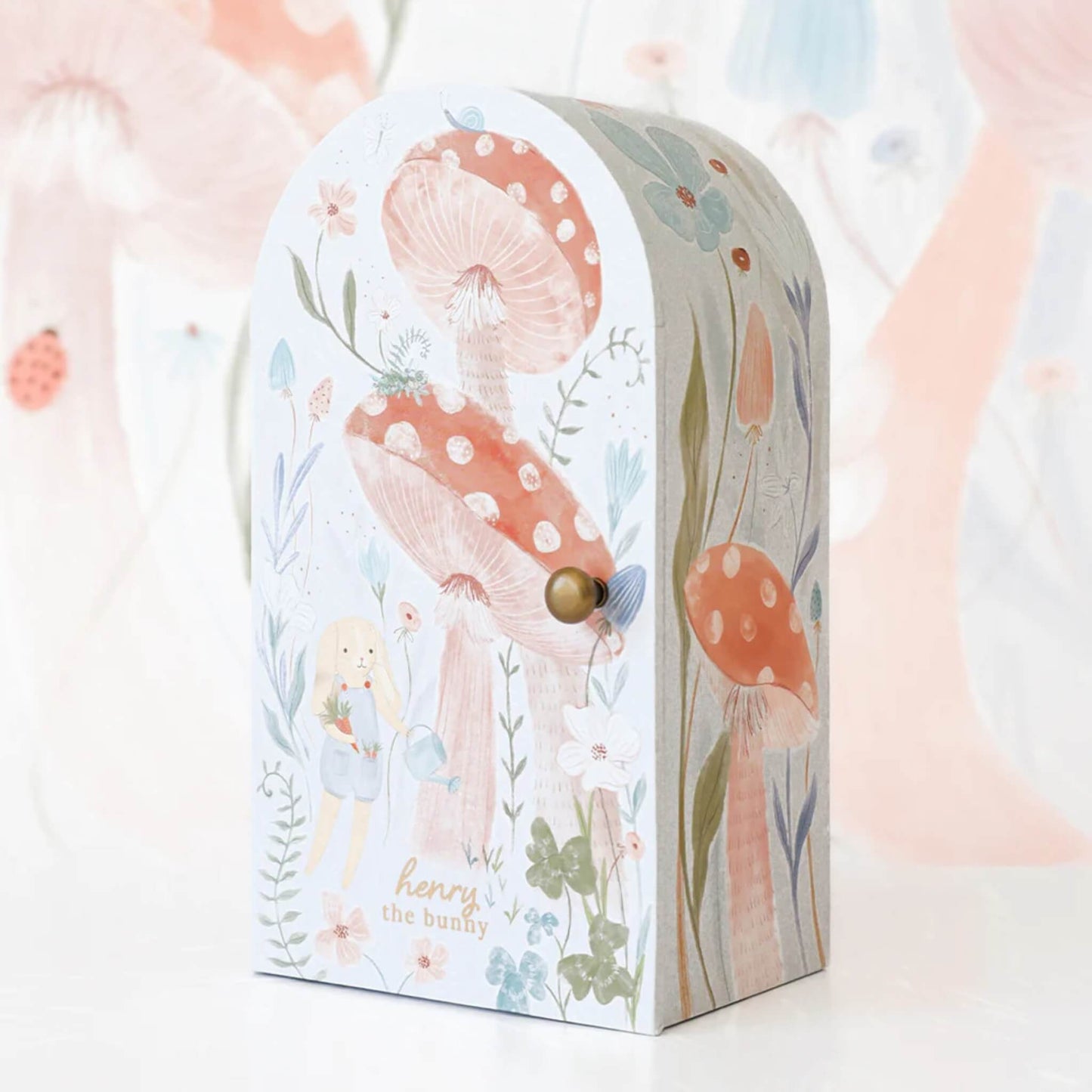 Illustrated keepsake box with mushroom and woodland design, featuring soft pastel tones and rounded top shape.