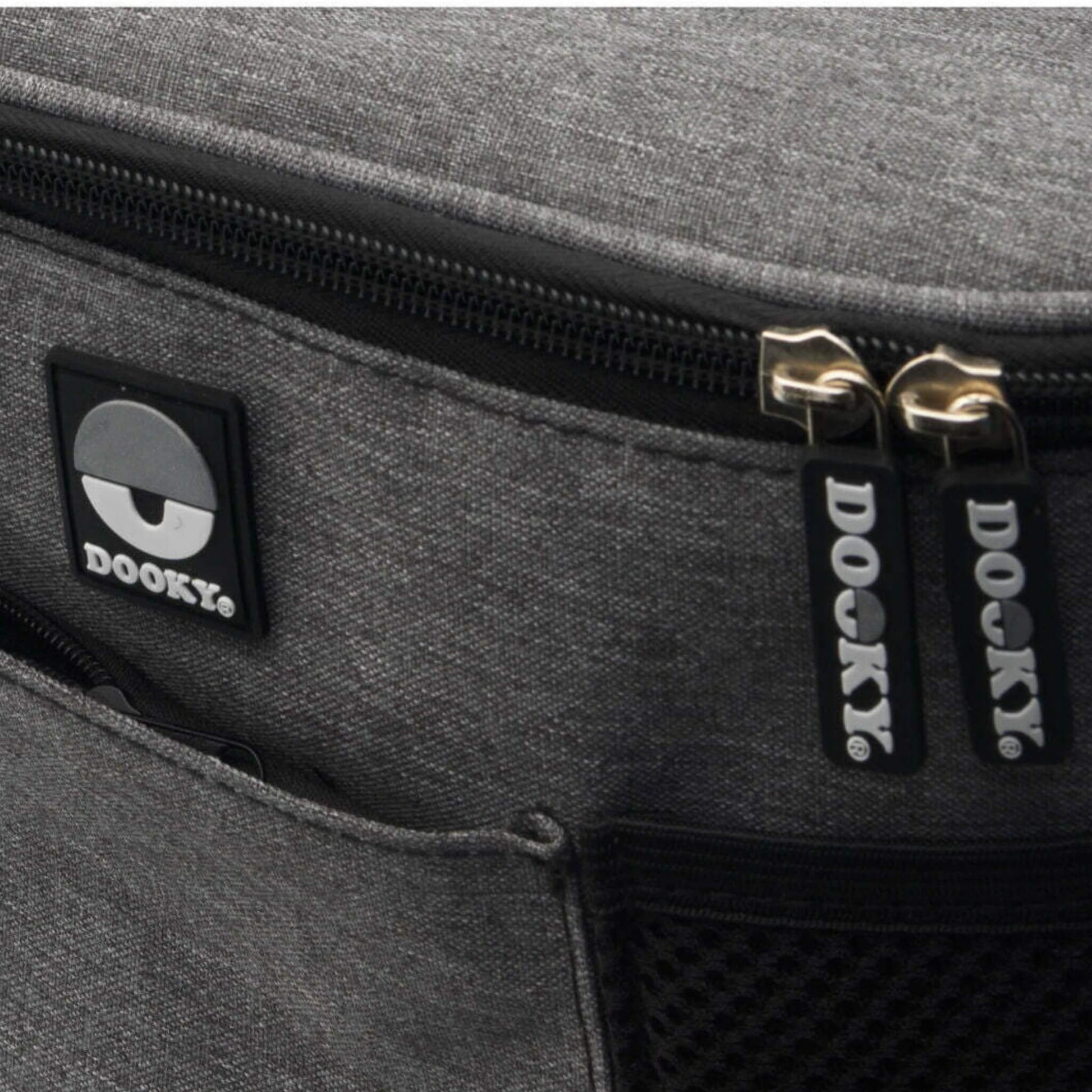 Close-up of grey fabric buggy organiser showing two branded Dooky zip pulls and part of the mesh pocket.