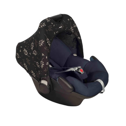 A Dooky Car Seat Hoody in a black and soft beige leaf print fitted to a navy infant car seat, providing shade, UV protection and a stylish update for travel.